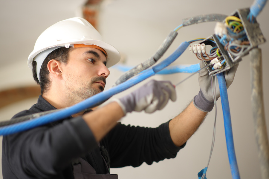 Electricista trabaja instalando un sistema eléctrico en una casa bajo reforma